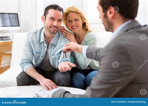 Real Estate Agent Delivers Keys Of New House To Young Couple Stock Image Image Of Property