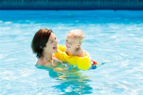 母亲和婴儿在户外游泳池的热带度假胜地。学习游泳的孩子。妈妈和孩子在水里玩耍。家庭暑假在异国情调的目的地。积极健康的儿童运动照片 正版商用图片0oz5bo 摄图新视界