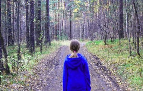 A Girl Walks Alone While Walking Through The Forest On An Autumn Day