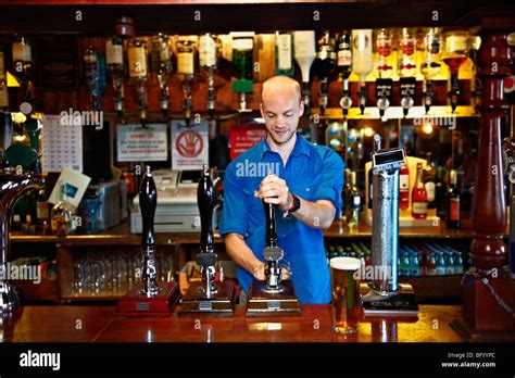 Barman Standing Behind Bar In Pub Stock Photo Royalty Free Image