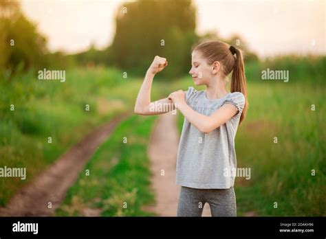 Child Cute Girl Show Biceps Gesture Of Power And Strength Outdoor Feel