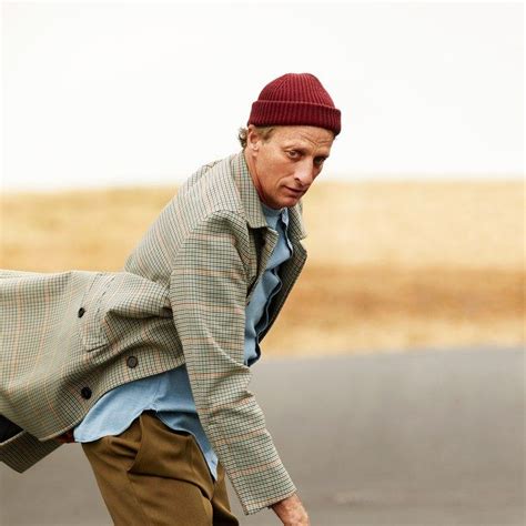 A Man In A Plaid Jacket And Red Hat Skateboarding