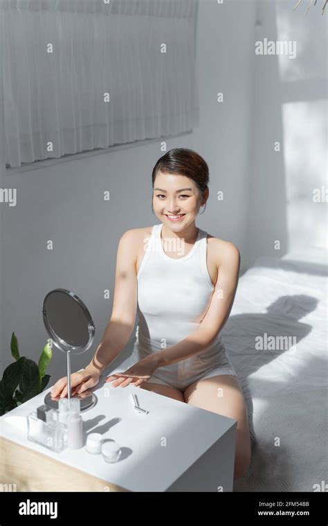 Portrait Of Beauty Smiling Asian Woman Applying Lotion Skin During Her Morning Routine Stock