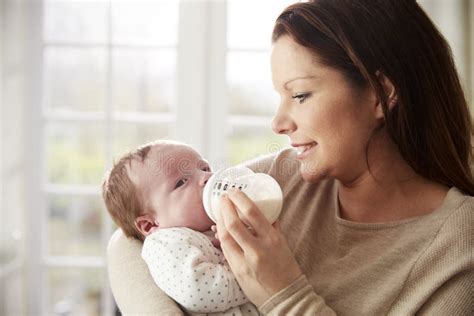 Mother Feeding Newborn Baby From Bottle At Home Stock Photo Image Of