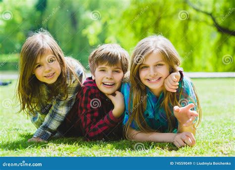 Smiling Kids Having Fun At Grass Children Playing Outdoors In Summer