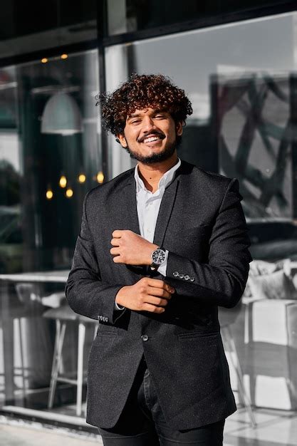 Free Photo Curly Haired Indian Businessman Stands Outside His Office