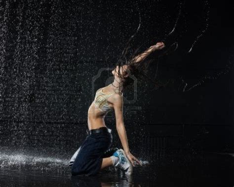 Het Mooie Meisje Dansen In Water Onder De Regen Op Een Zwarte