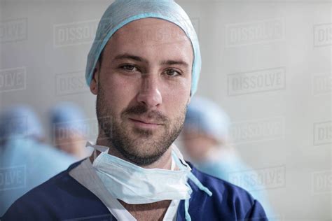 Portrait Of Male Surgeon Wearing Scrubs And Surgical Mask Stock Photo