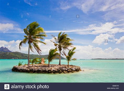 A small island with palm trees off the shore near the airport on Bora 