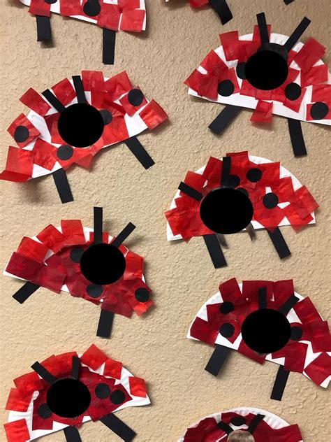 Red And Black Paper Flowers Made To Look Like Ladybugs On A Wall With Holes In The Middle
