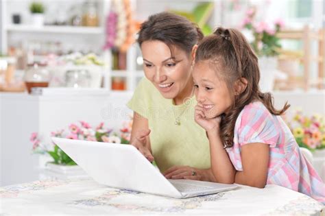 Mother And Daughter Looking At Laptop Computer Stock Image Image Of