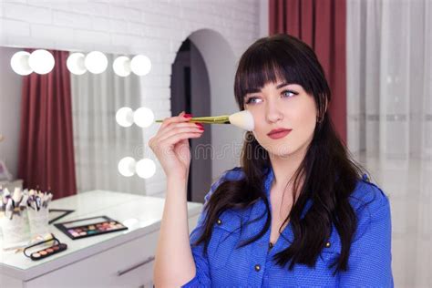 Makeup Artist Makes Makeup On Face With Makeup Brush Stock Photo