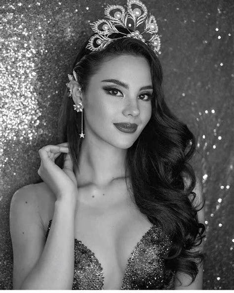 a beautiful woman wearing a tiara in front of a glitter wall with her hand on her shoulder
