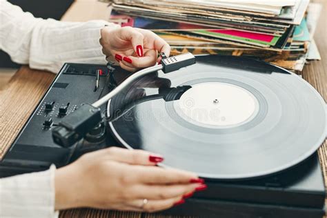 Young Woman Listening To Music From Vinyl Record Player Playing Music