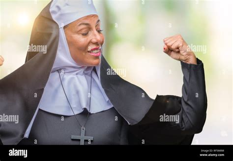middle age senior christian catholic nun woman over isolated background showing arms muscles