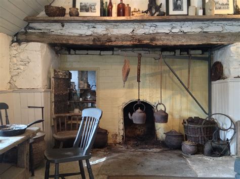 An Old Fashioned Fireplace With Pots And Pans On The Mantel In A Rustic
