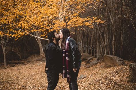 Couple In Love Caressing On Autumn In The Autumnal Forest Enjoying A