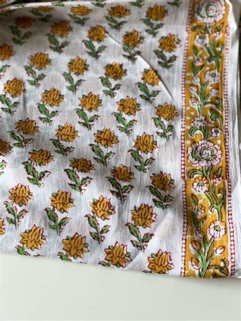The Fabric Is White With Yellow Flowers On It