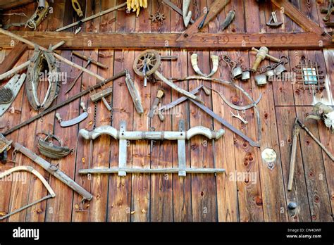 Old woodworking tools and farming implements fixed to the side of a