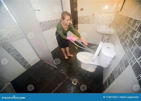 Asian Female Maid Or Housekeeper Cleaning Spray Water Closet Stock