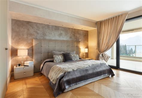 This primary bedroom boasts stylish walls and rug set on the tiles flooring. 32 Bedroom Flooring Ideas (Wood Floors)