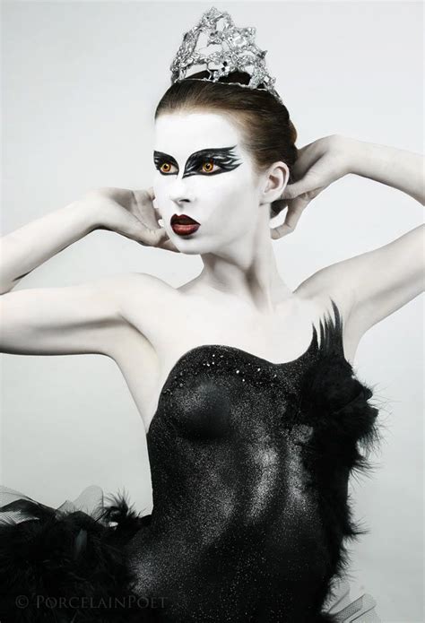 A Woman In Black And White Makeup With Feathers On Her Head