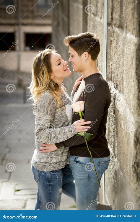 Candid Portrait Of Beautiful European Couple With Rose In Love Kissing