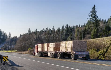 Red Big Rig Powerful Semi Truck Transporting Lumber On Two Flat Bed