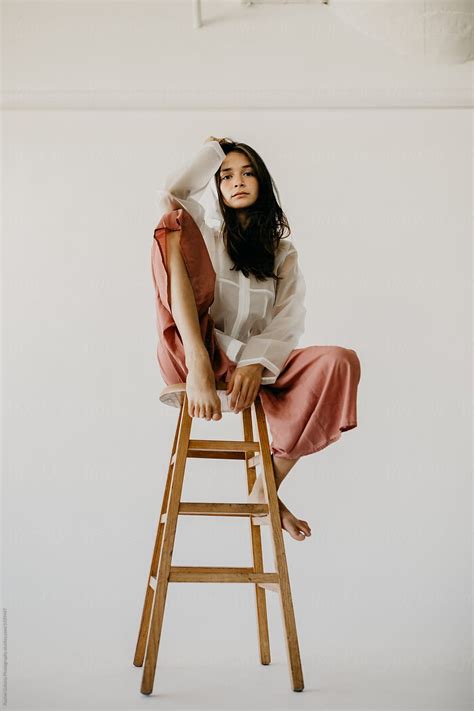 Woman Model Posing On A Stool In Culottes And A Raincoat Stocksy United Chair Photography