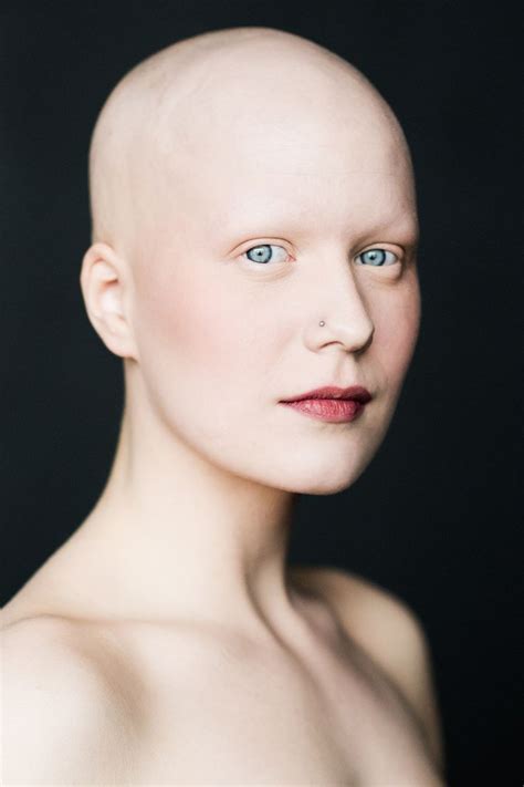 a bald woman with blue eyes and no shirt