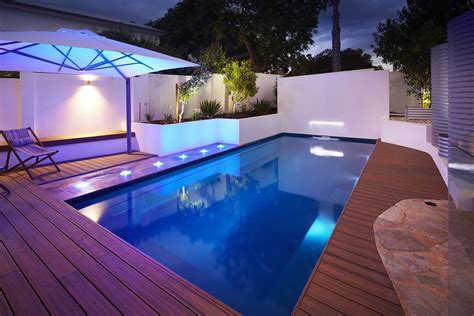 Sparkling Bluish Pool Featuring Stone Paving And Timber Decking By Multi