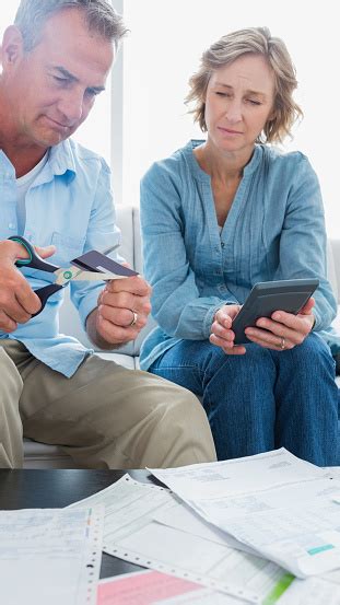 Wife Watching Her Husband Cut Credit Card In Half 照片檔及更多 40多歲 照片 40多歲