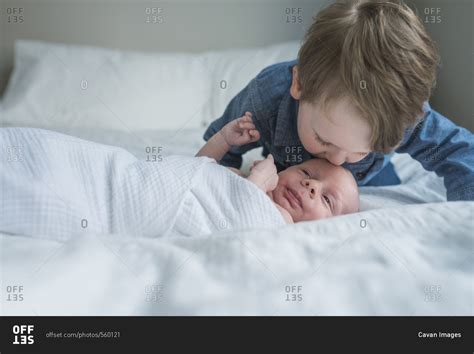 Boy Kissing Brother S Forehead On Bed At Home Stock Photo Offset