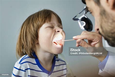 Doctor Checking Tonsils Of Patient At Hospital Stock Photo Download