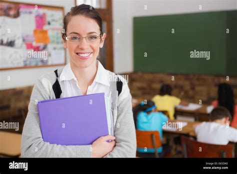 Pretty Teacher Smiling At Camera At Back Of Classroom Stock Photo Alamy