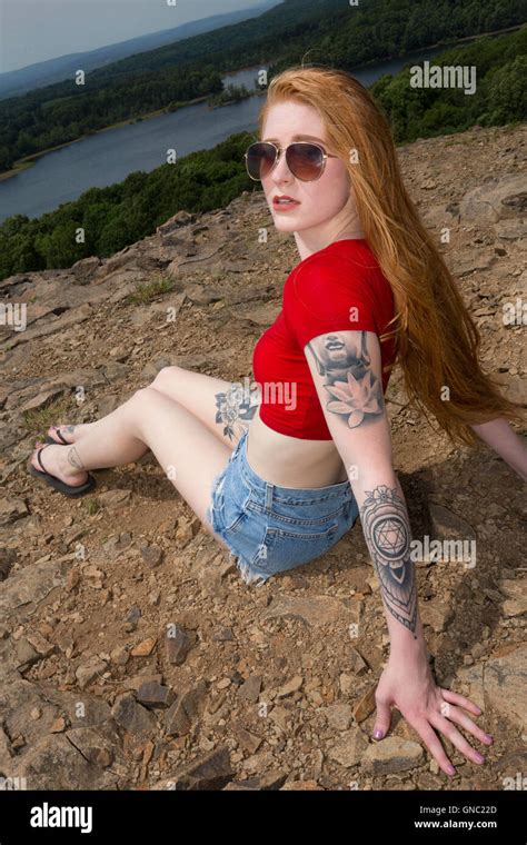 Beautiful Woman With Long Red Hair In Jeans Shorts And Red Shirt