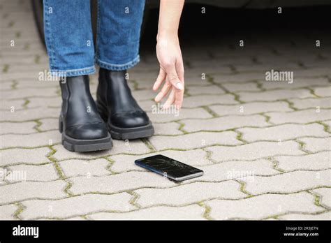 Woman Taking Dropped Smartphone From Pavement Closeup Device