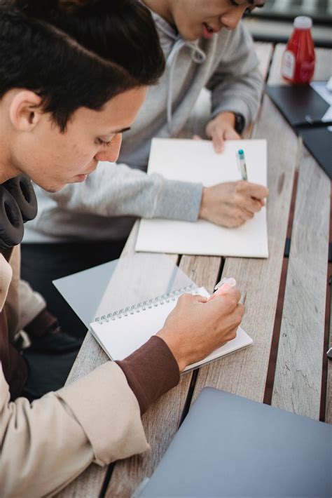 Focused Students Taking Notes At Table · Free Stock Photo