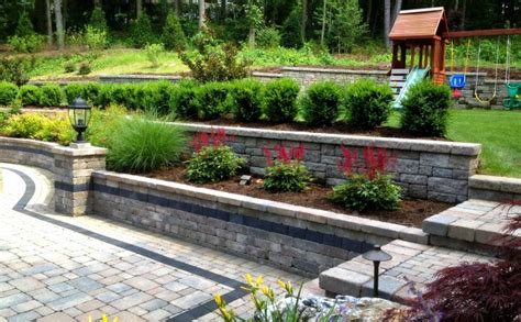 Don't underestimate those drab gray building blocks. Patio Backyard Tiered Retaining Wall Construction Professionals Autumn Leaf Stackable Block Do ...