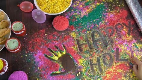 Hands Of An Indian Female Writing Happy Holi Text On Colorfu