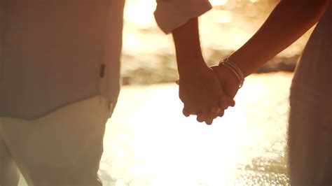 pareja caminando tomados de la mano en la playa 1615303 vídeo de stock en vecteezy