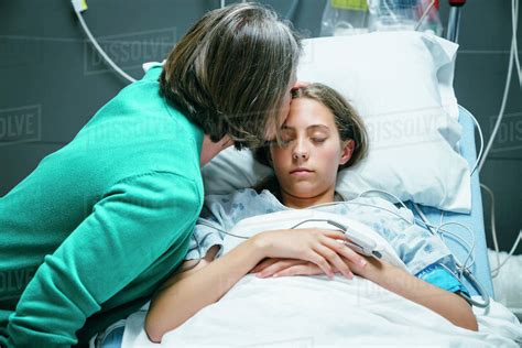 Caucasian Mother Kissing Your Daughter On Forehead In Hospital Stock