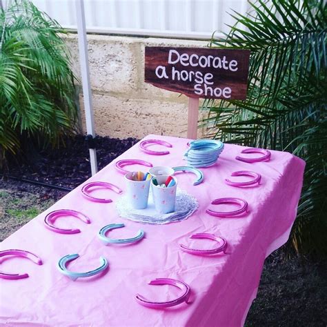 A Pink Table Topped With Plates And Cups Next To A Sign That Says