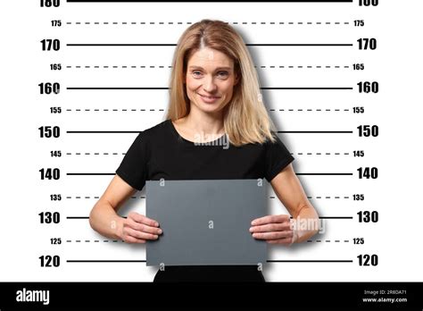 Criminal mugshot. Arrested woman with blank card against height chart
