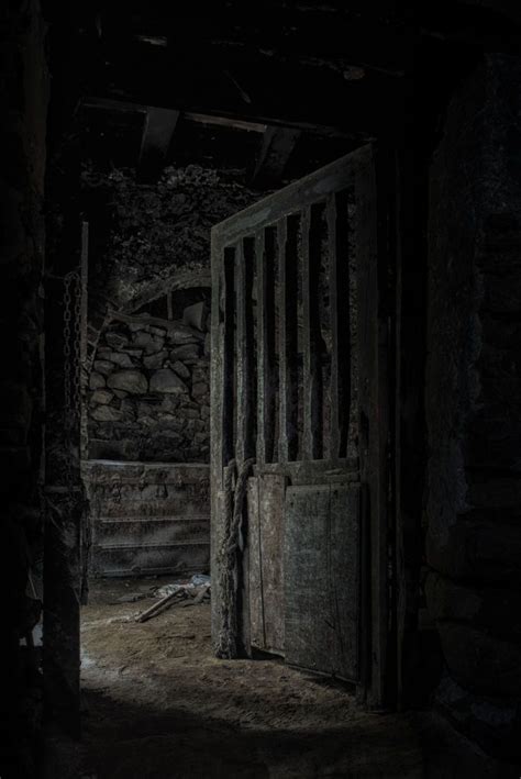 An Open Door In A Dark Room With Stone Walls