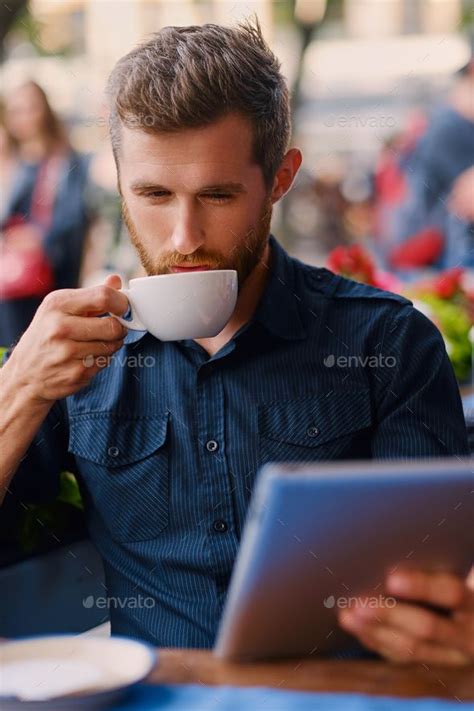 A Man Drinks Coffee And Using A Tablet Pc In A Cafe Coffee Drinks Coffee Shop Photography