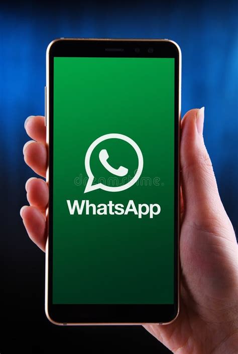Hands Holding Smartphone Displaying Logo Of Whatsapp Messenger