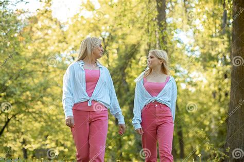 Mom And Daughter Dressed In Same Outfit Walk Outside Together Women Look At Each Other With