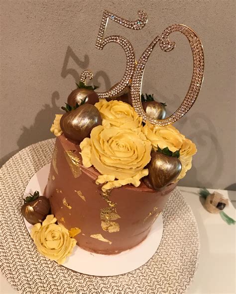 A Chocolate Cake With Yellow Flowers And The Number 50 On Top Is