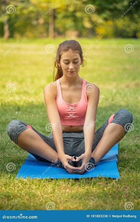 Young Fitness Woman Stretching Her Leg To Warm Up Sitting On Mat At Park In The Morning Sport